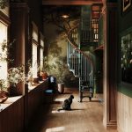 American Industrial spiral staircase framed by an archway leading into a home library hallway