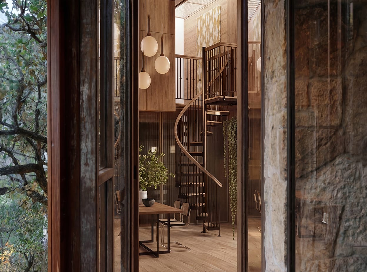 Indoor spiral staircase with wood treads and metal spindles, viewed through a stone entryway