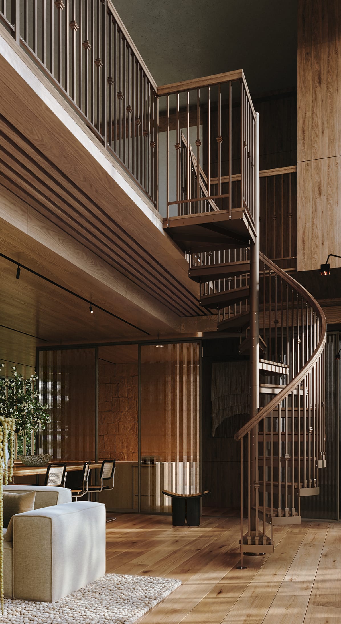 Indoor spiral staircase with wood handrail and metal spindles in a two-story great room